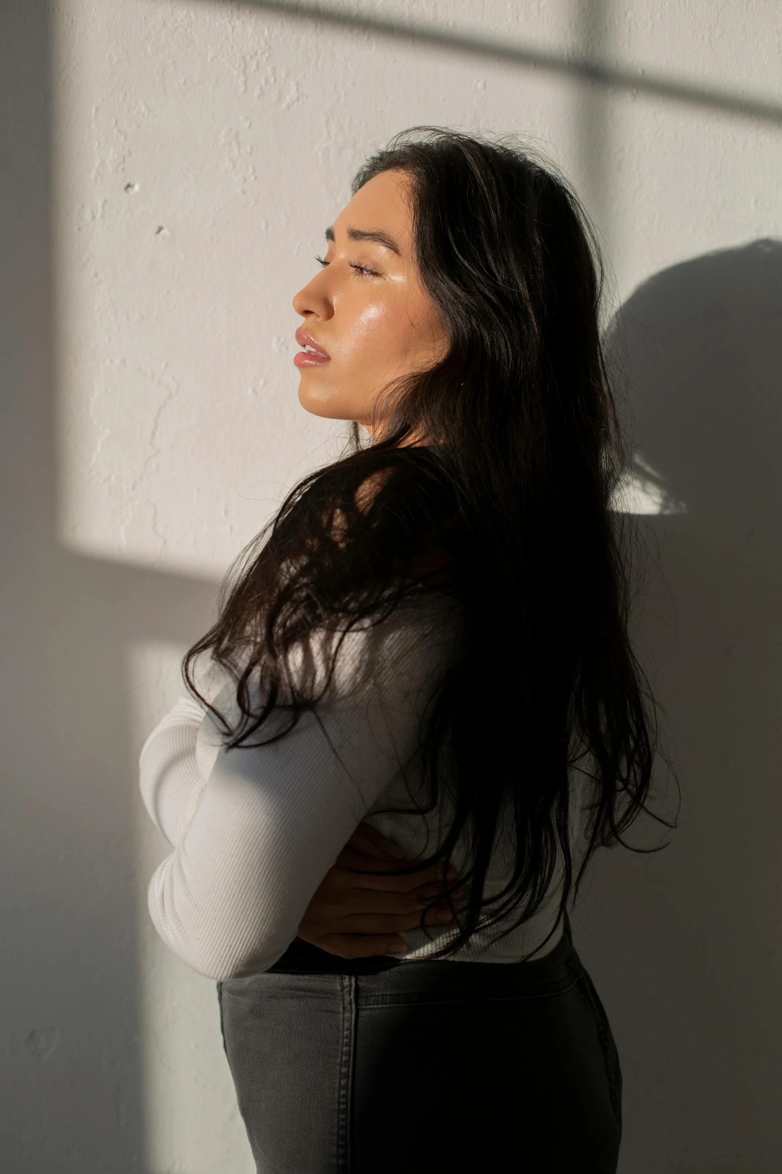 a woman standing next to the wall posing for the camera