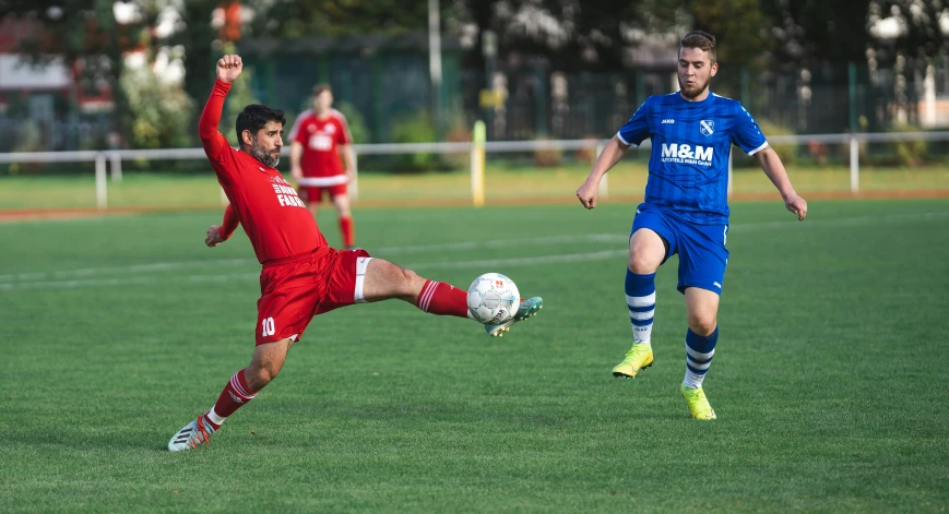 two men on opposing teams going after the soccer ball