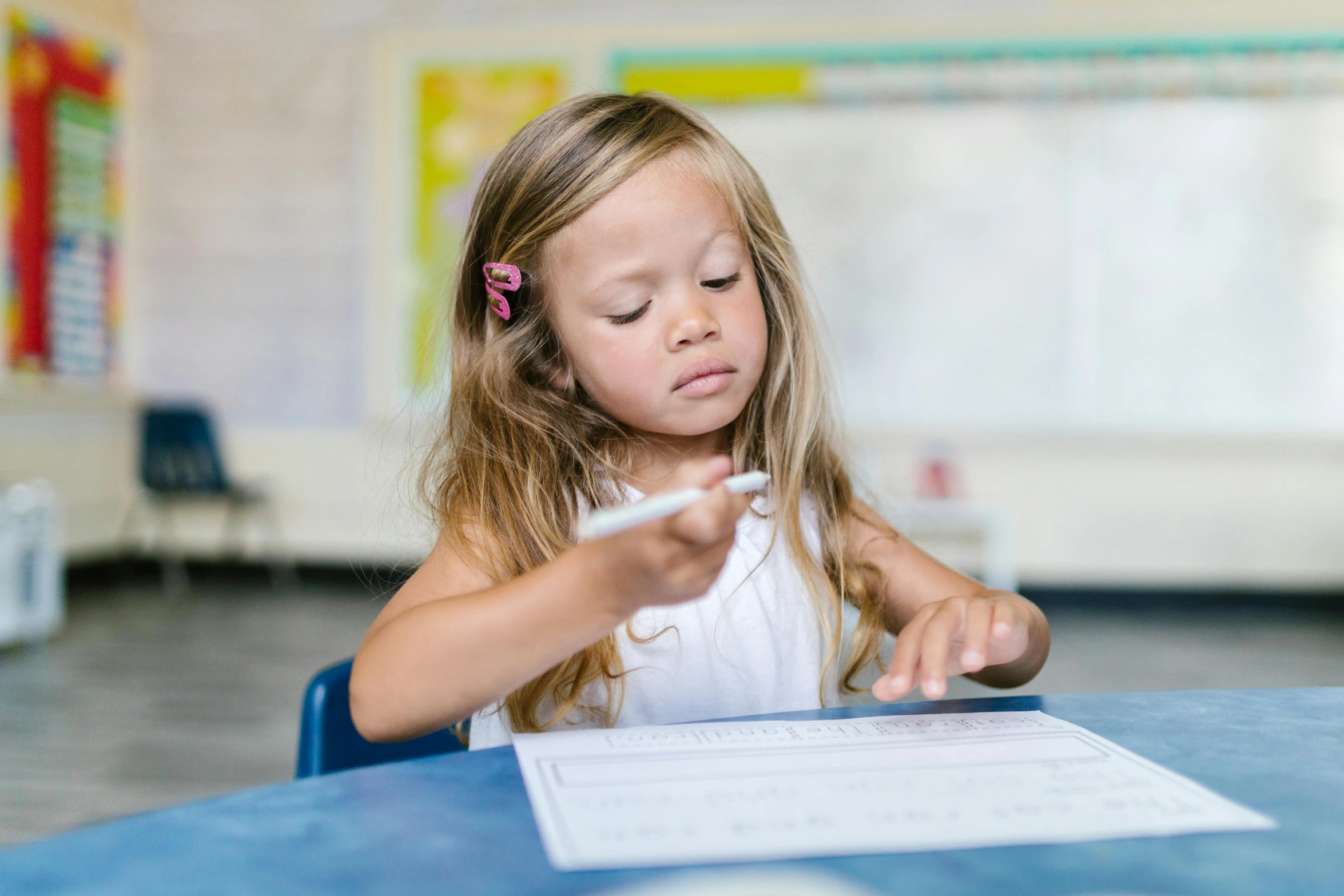 a girl sitting at a table looking at papers