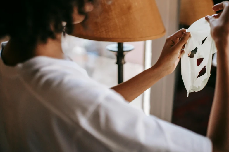 a woman is sewing on a sheet of white paper