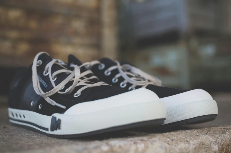 black and white sneaker on stone slab with no shoe laces