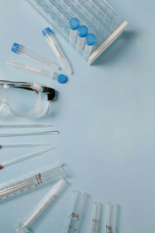 a blue background has medical utensils and eyewear on it