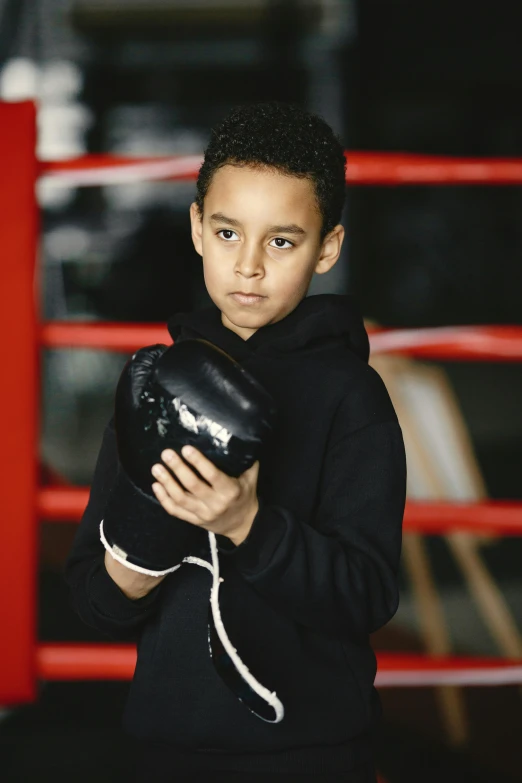 a  in black standing by a boxing ring