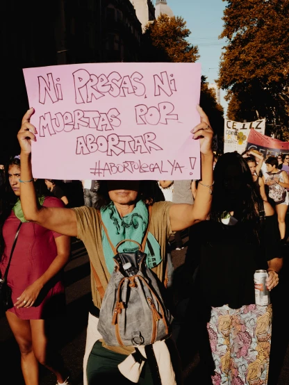 protestors holding up a pink sign in a protest
