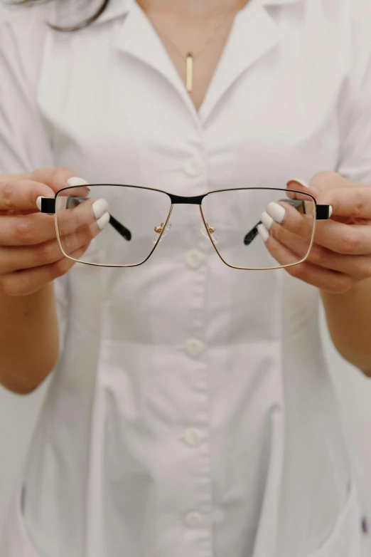 a woman wearing glasses and holding one