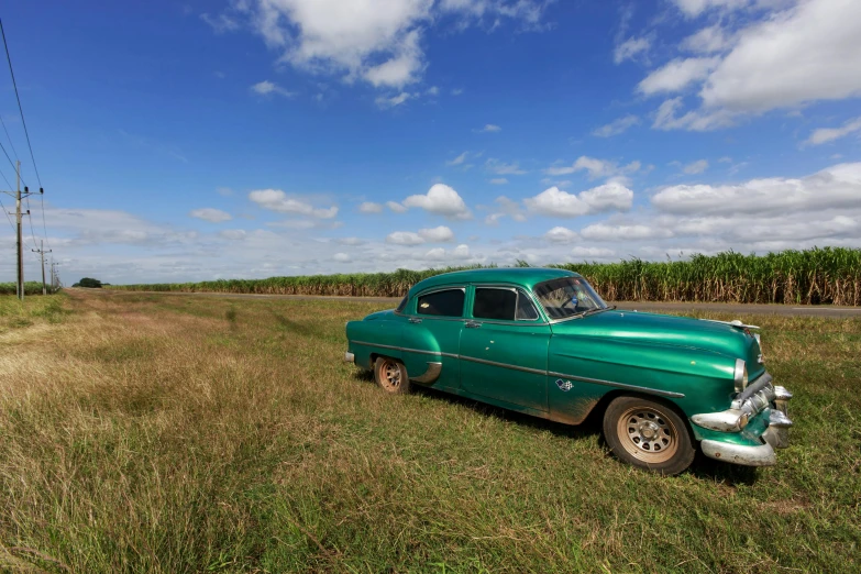 an old truck parked in a field of tall grass