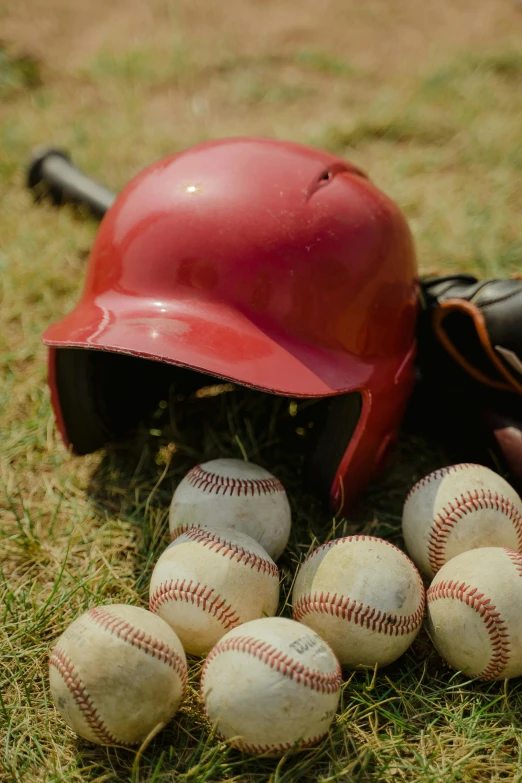 a baseball and helmet are sitting on the grass