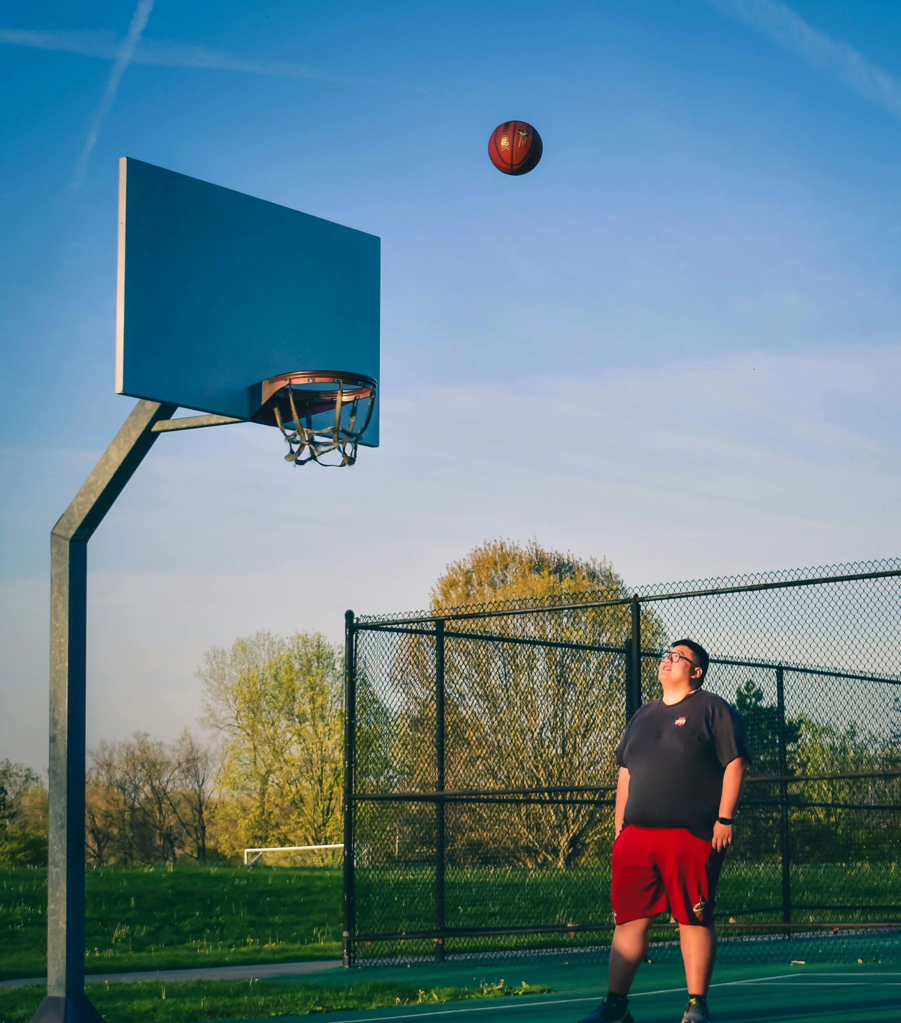 a man is playing basketball in the park