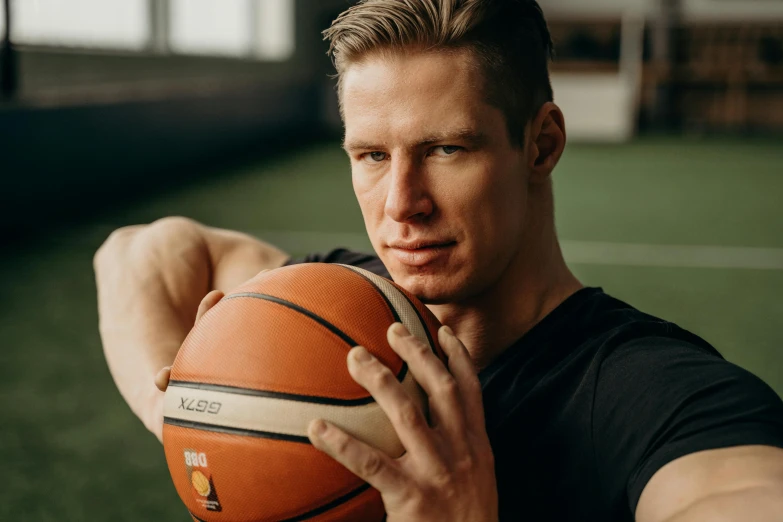 a man holds a basketball near his face