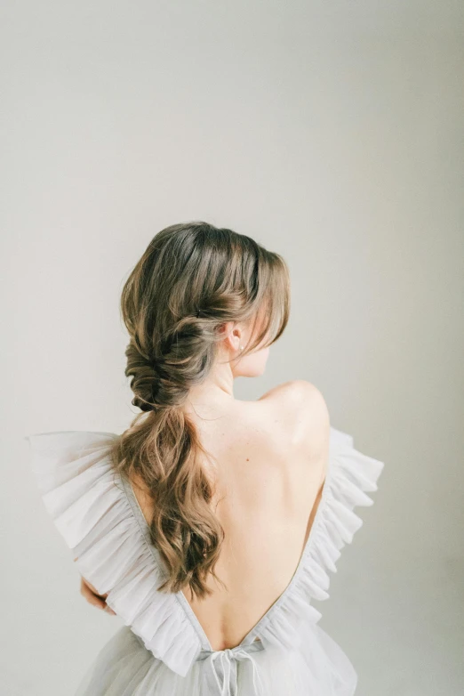 a woman with a ponytail and ruffled hair in her dress