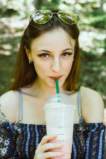 young woman drinking fresh frothy cold beverage