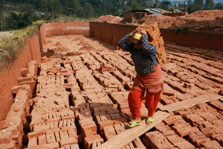 a man with a back pack walks in front of several bricks