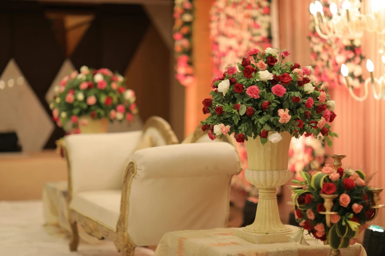 a fancyly decorated chair and table in front of flowers