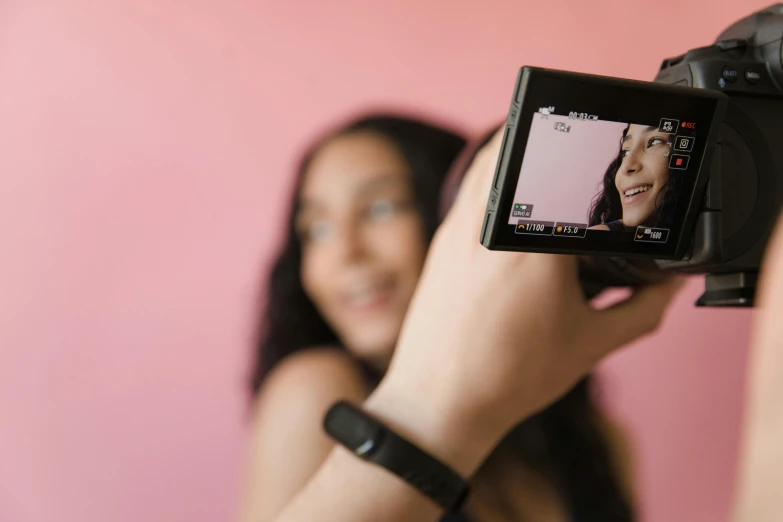 a woman smiling with a camera on her hand