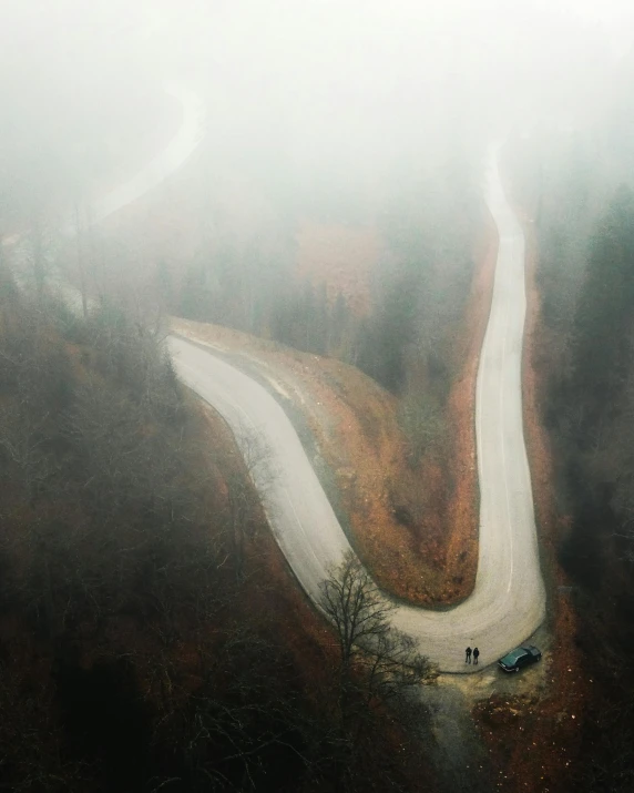 long winding road in mountains in the fog