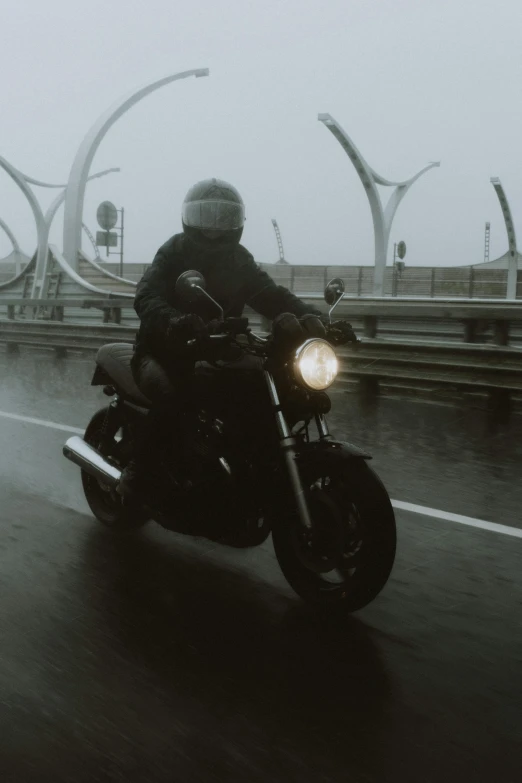 a person riding a motorcycle on a wet road