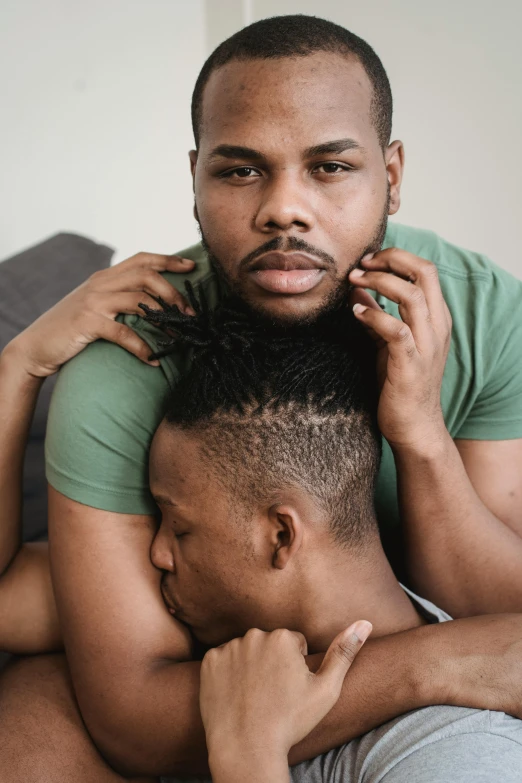 two men hugging each other and one of them is pulling the others hair