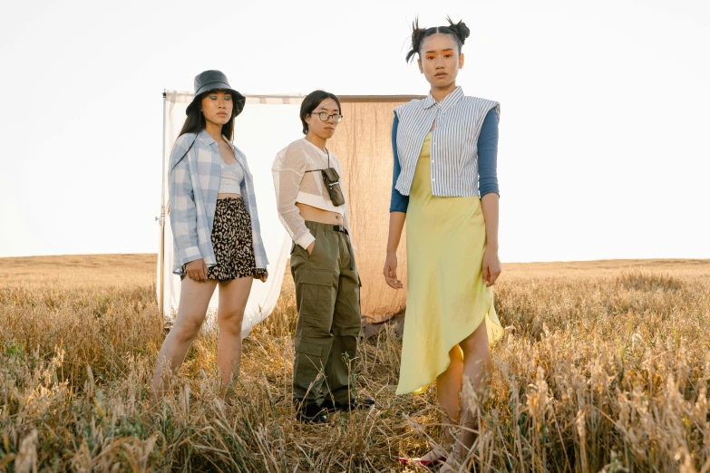 three women standing in the middle of a field