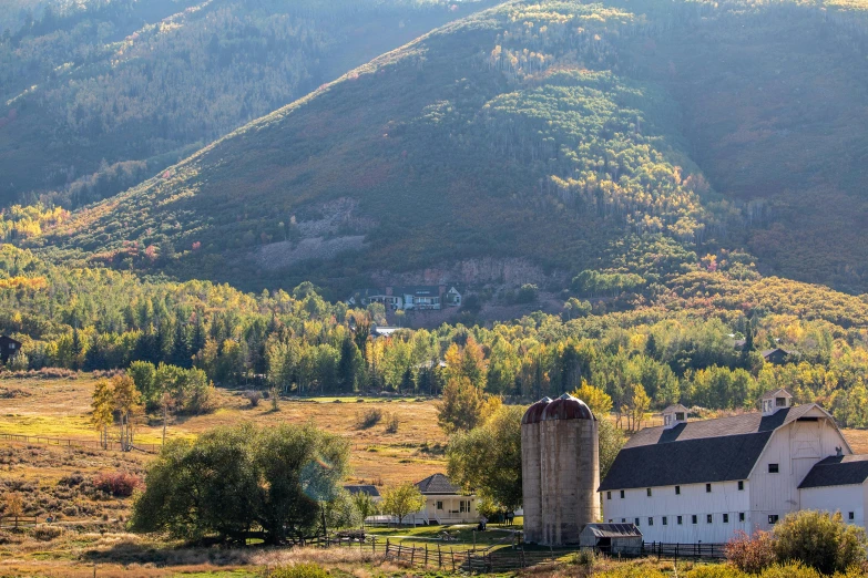 the hillside view has a large silo in the foreground