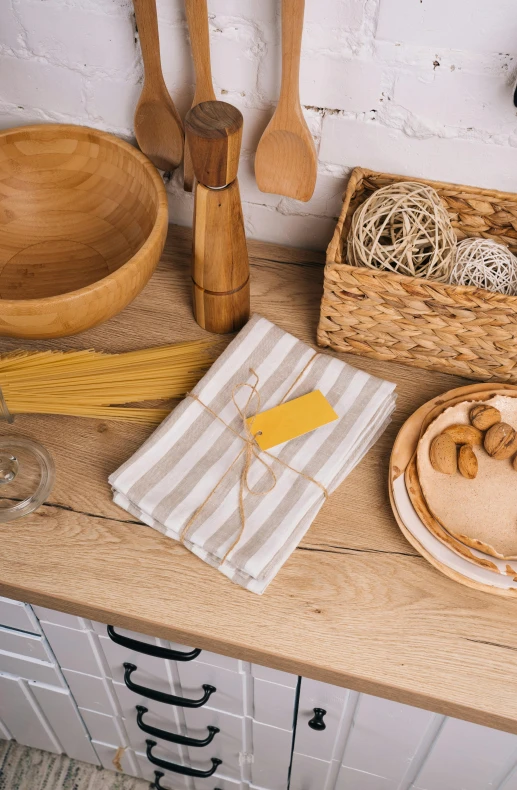 a counter with  implements, an empty dishwasher and a wooden spoon