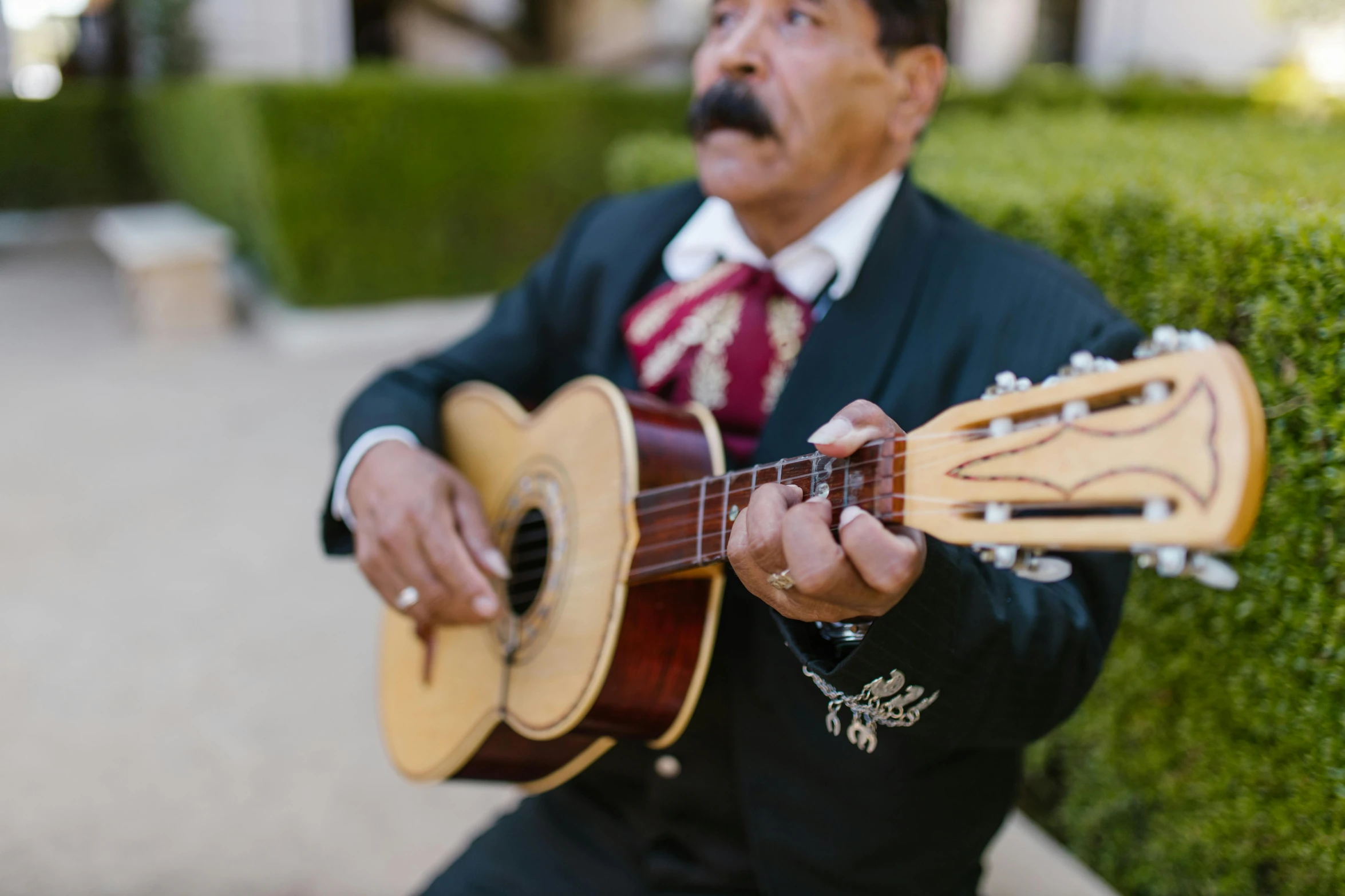 the man is holding an acoustic guitar outside