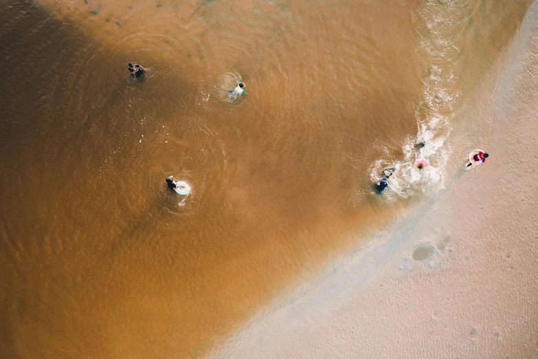 an aerial view of several small, brown boats on the water