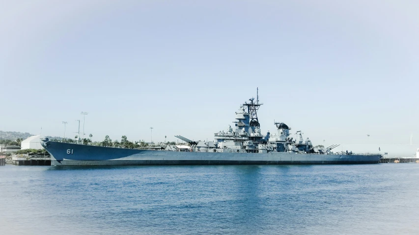 a large gray ship floating in the middle of a large body of water