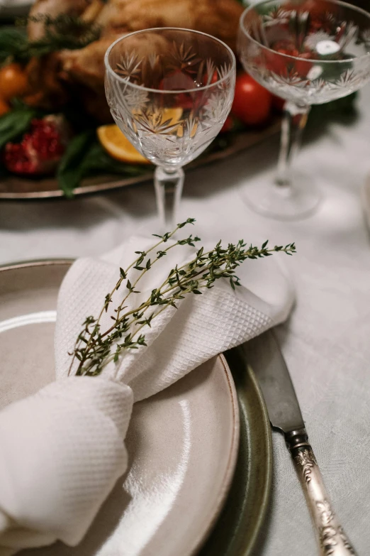 a table with white cloth, silverware and plates