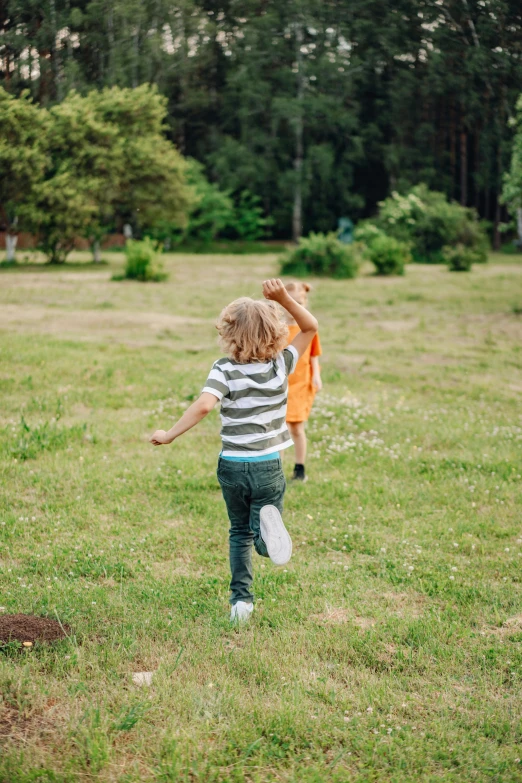 a little girl standing in the grass with a frisbee