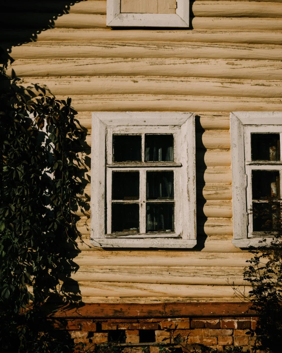 two open windows sitting next to a wall of wood