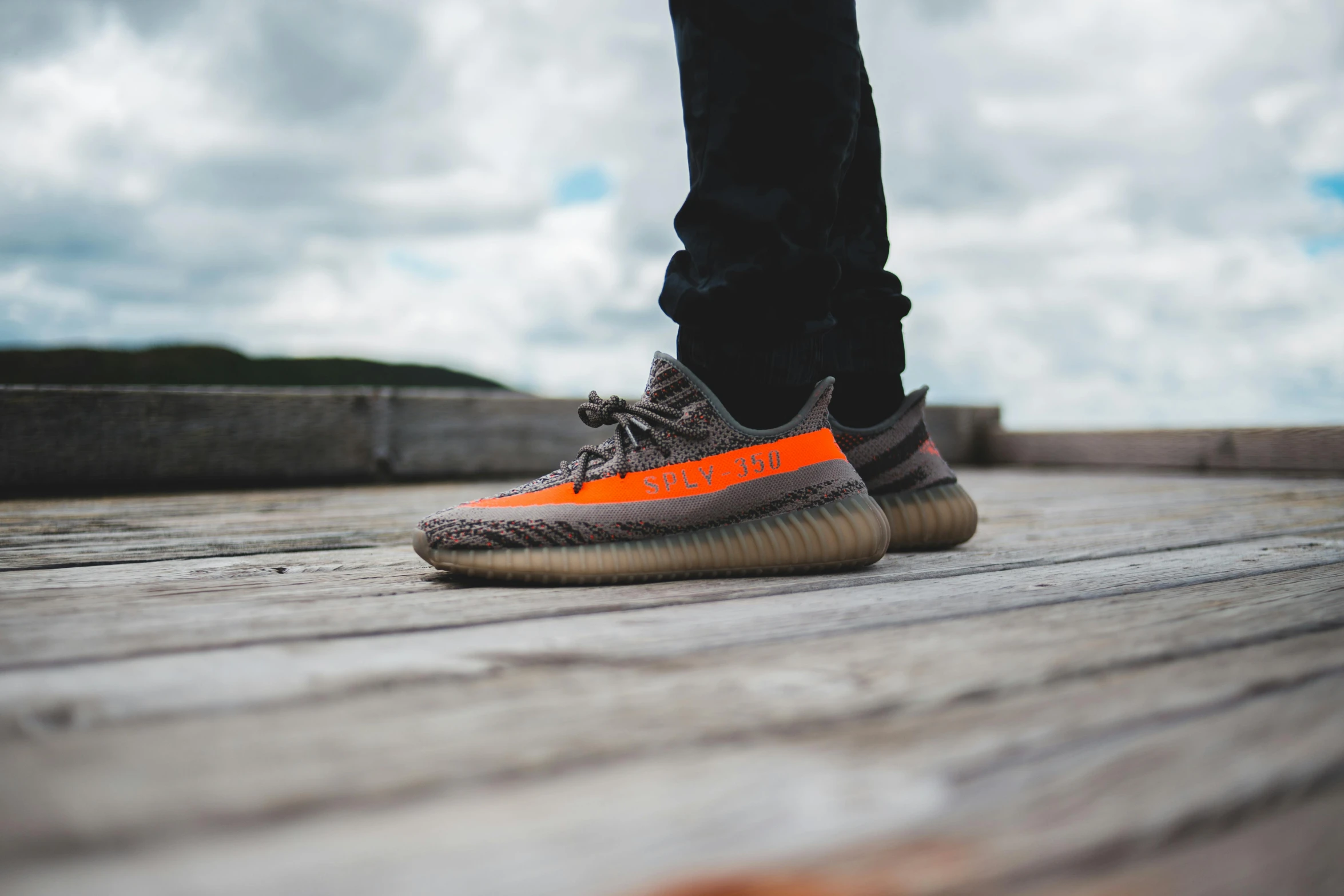 a man standing on a deck with the sneakers off