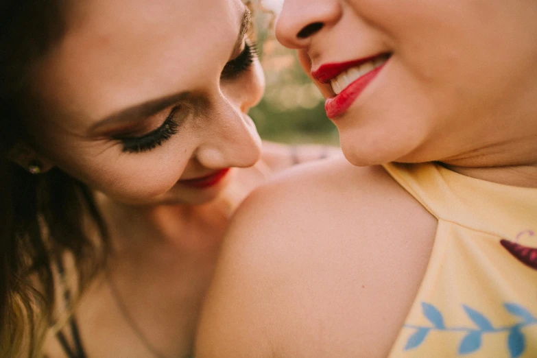 two beautiful women with closed eyes staring at each other