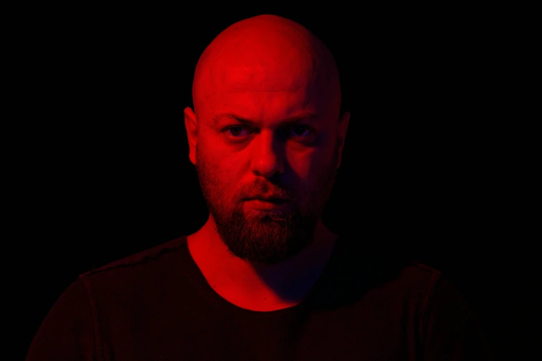 a man with a bald head wearing a black shirt