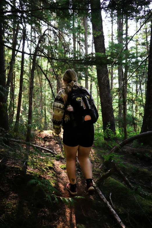 a young man hiking through the forest wearing hiking gear