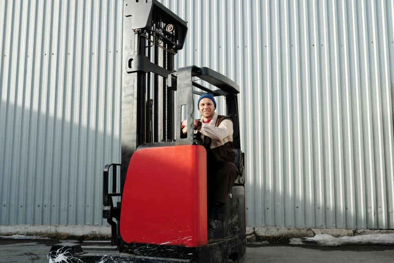 a man with a forklift looking out the window