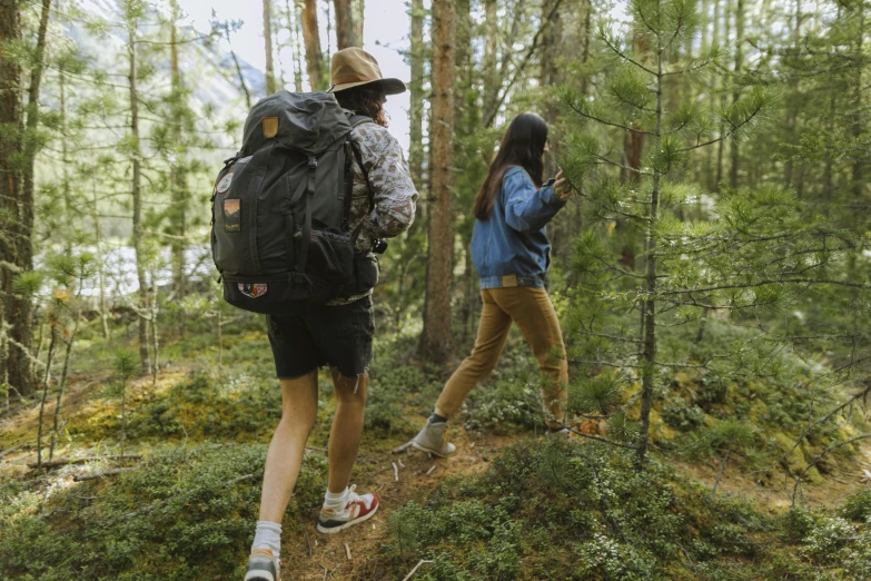 two people walking on a path through the woods