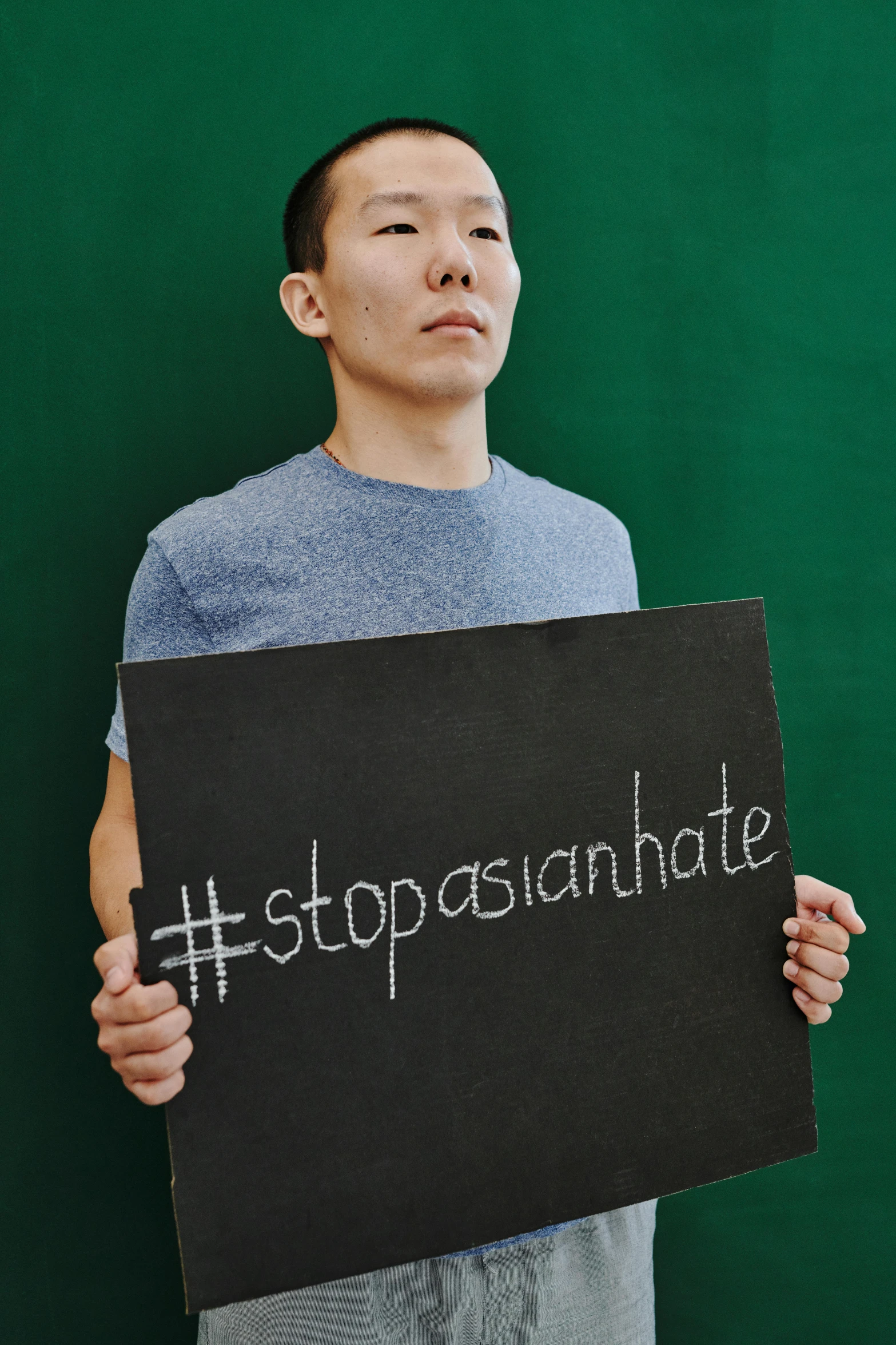 a man holding up a sign that reads stop pasquatte