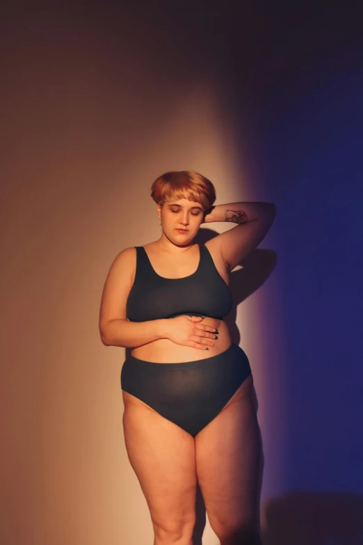 a woman in black bikini shorts, holding her hand on her hip