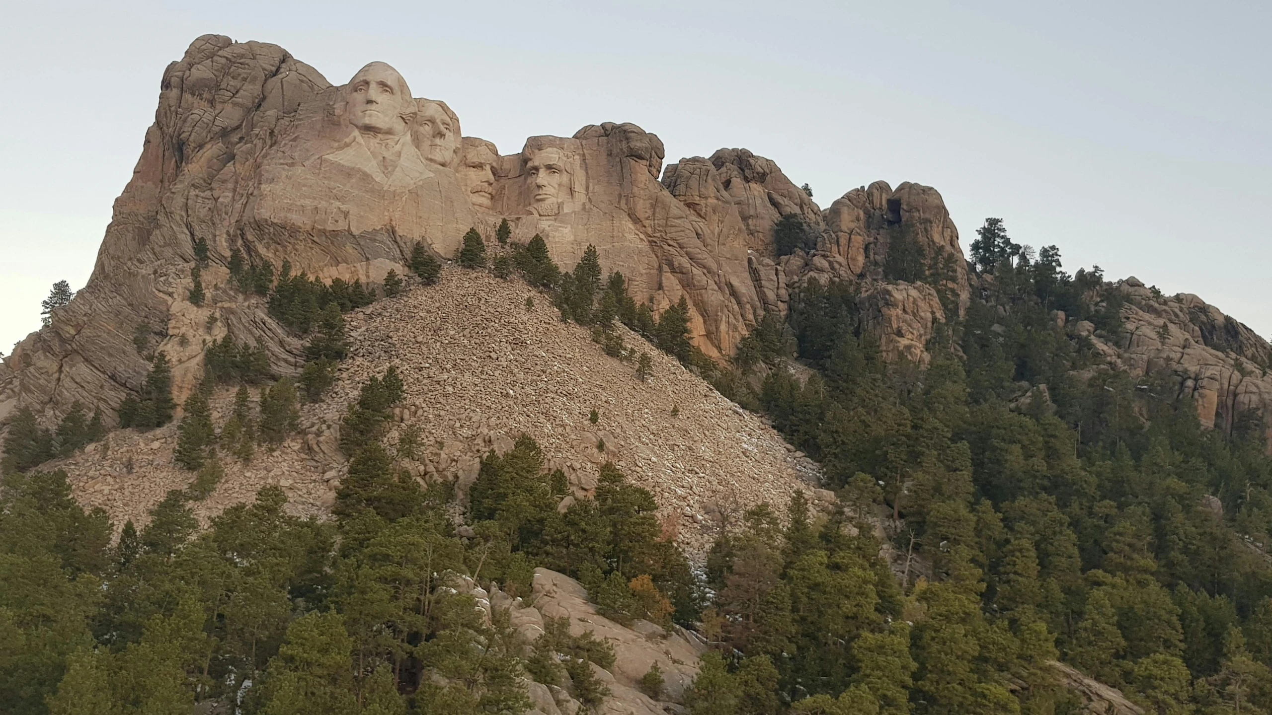 trees are growing around the rock formations on the mountain