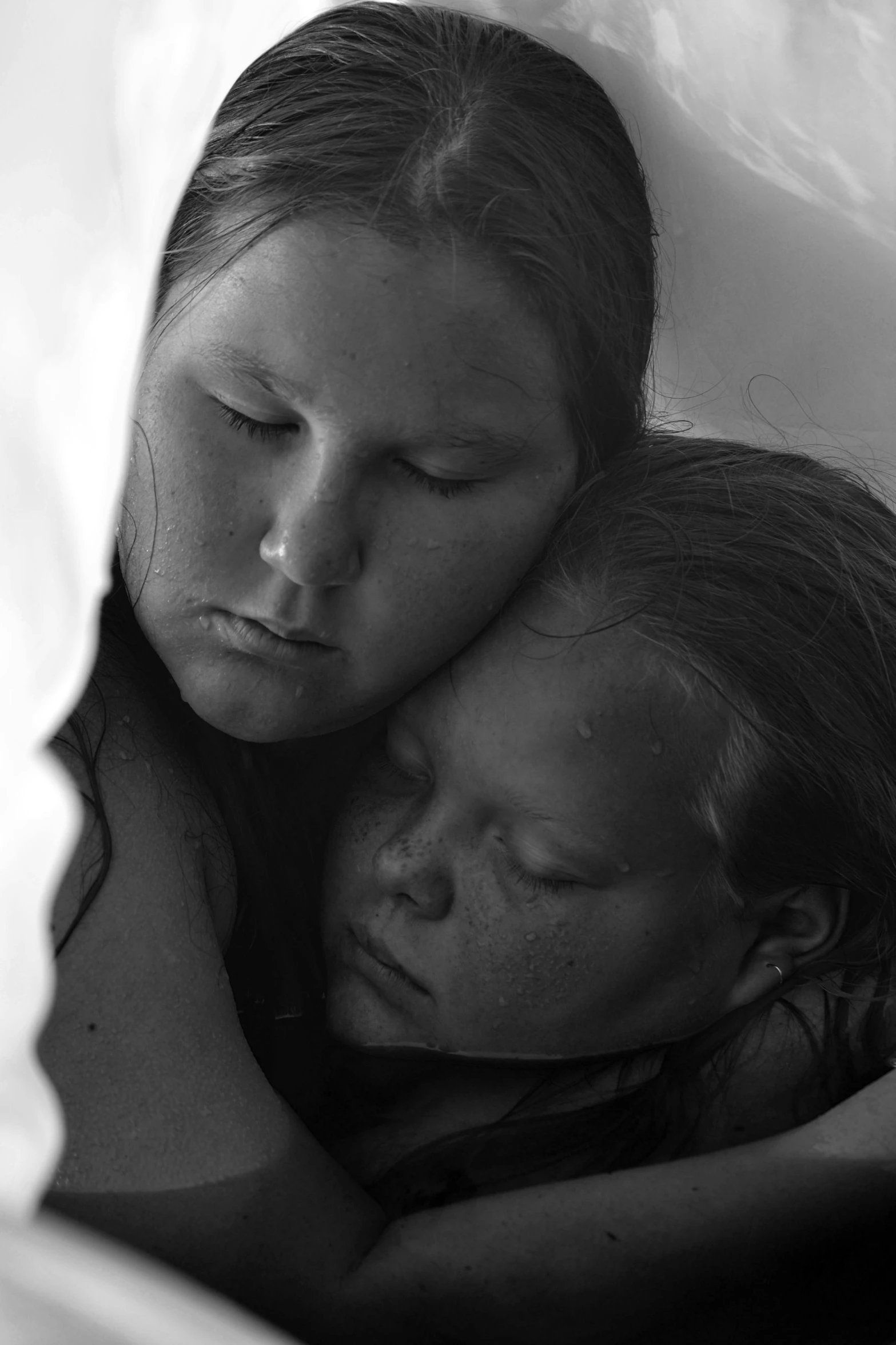 two women emcing each other while laying in bed