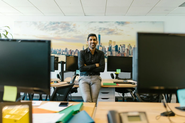 a man sitting in an office with his arms crossed