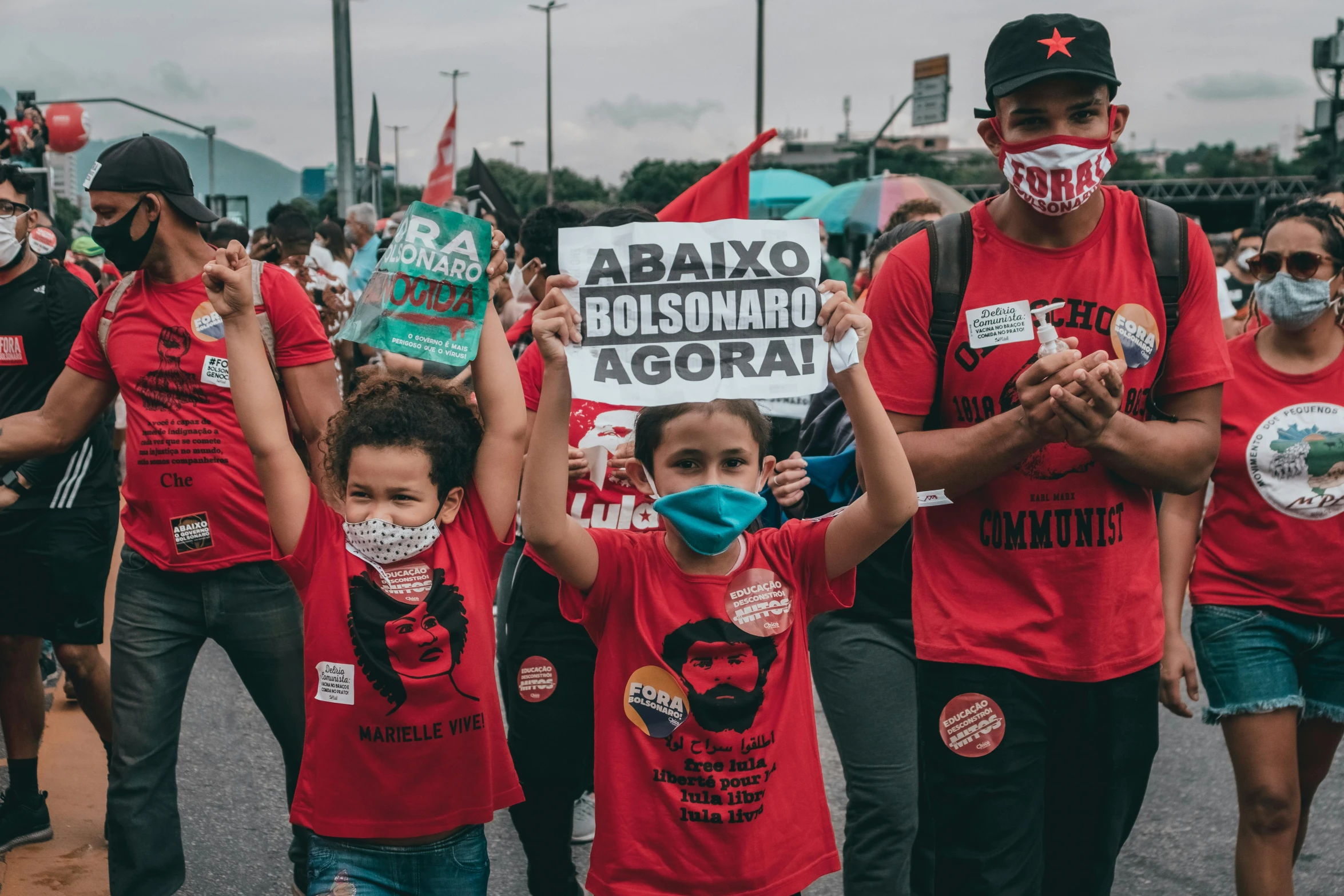 several protesters with face masks and flags are marching through the street