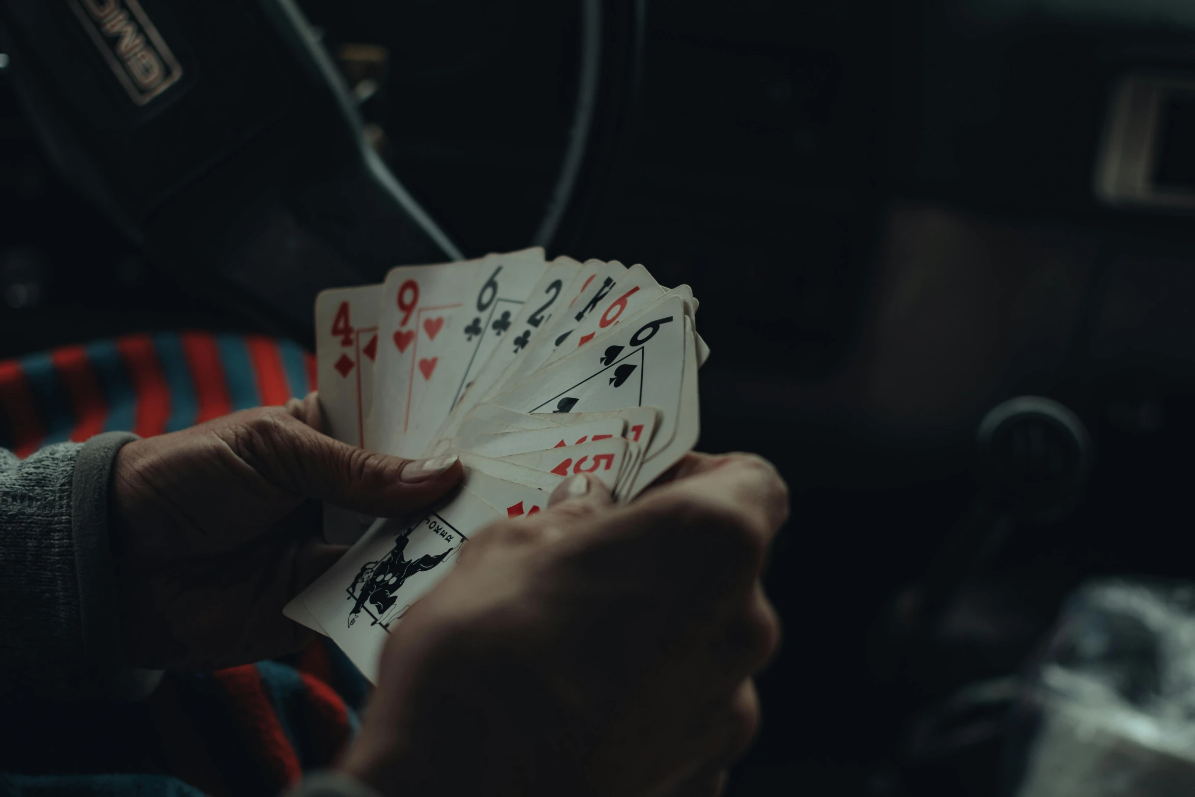 a person is playing cards while sitting in the backseat