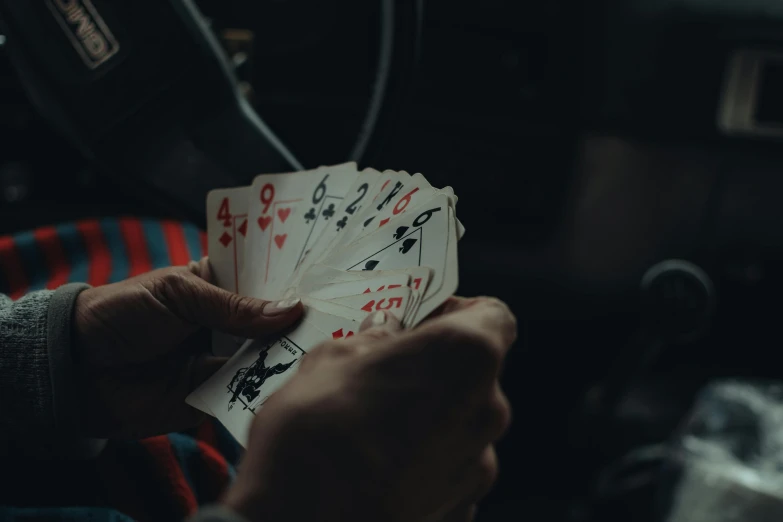 a person is playing cards while sitting in the backseat