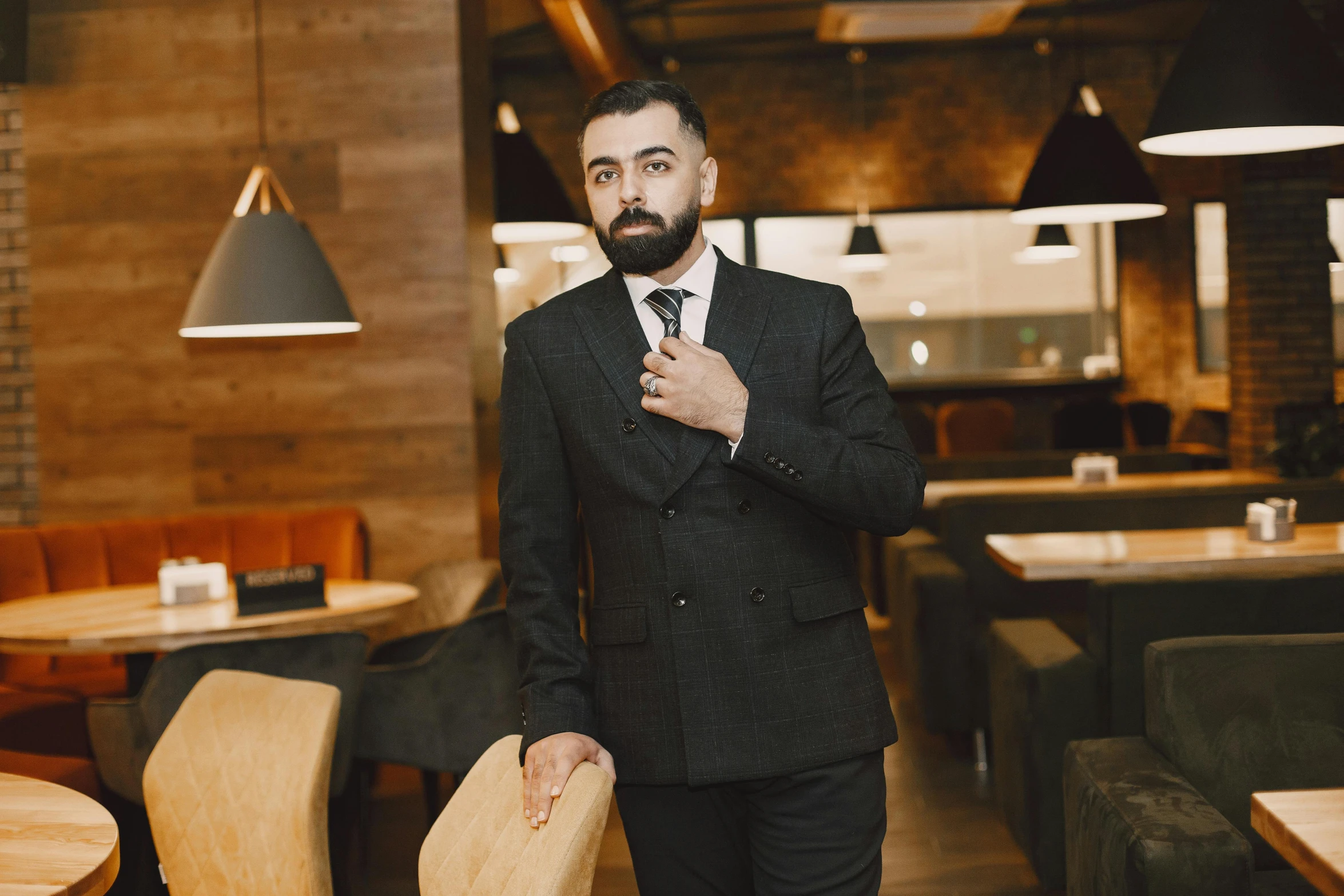 a man in suit and tie standing next to a table