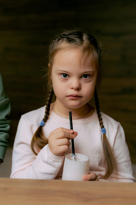 a  holding a black straw in her hand