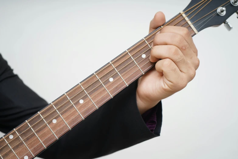 a man holding a black guitar string with one hand