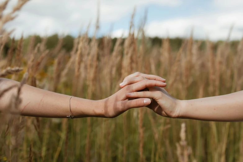 two people standing on their arms in a field