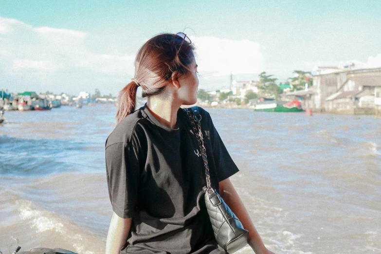 young woman sitting on wooden dock looking out over water