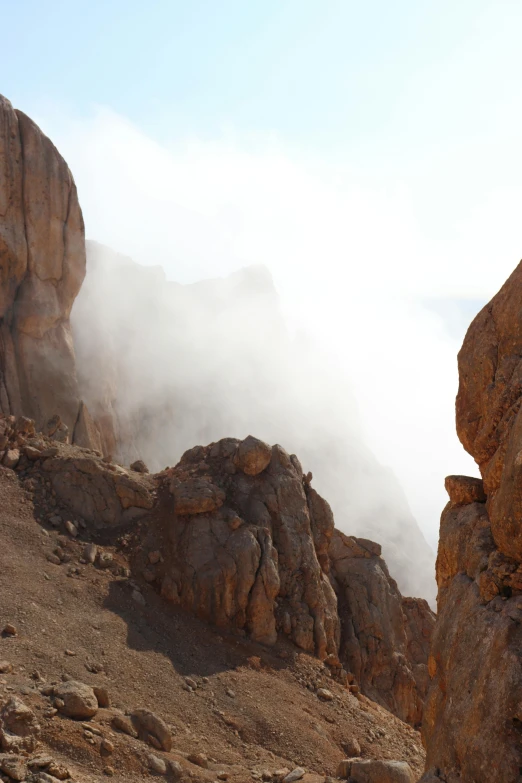 the fog is flying in the mountains on the rocks